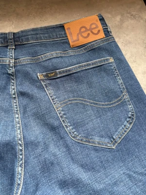 Blå raka jeans från Lee - Raka jeans från Lee i storleken 33/32 som endast är använda en gång.  Skick: Nyskick Mått: 73cm, 43cm (se bilder) Skickas inom 24h!  Hör av dig om du undrar något, svarar snabbt!    