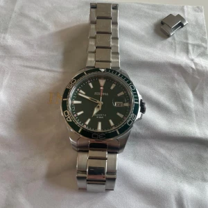 Festina klocka grön  - Det är en festina klocka med grön urtavla. Inga skador på klockan men armbandet är lite repat. Säljer klockan då jag inte använder den. En extra länk kommer vid köp.