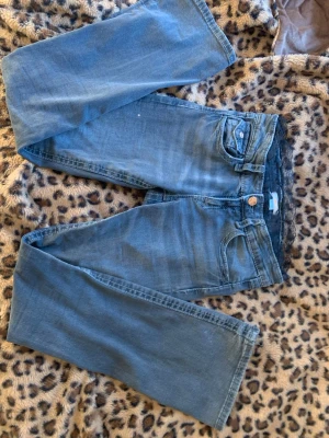 Svarta bootcut jeans från Gina Tricot - Säljer ett par blå jeans från Gina Tricot i rak modell. Jeansen har klassisk femficksdesign, knappgylf och är tillverkade i mjukt denimtyg. Perfekta för en avslappnad och trendig look.