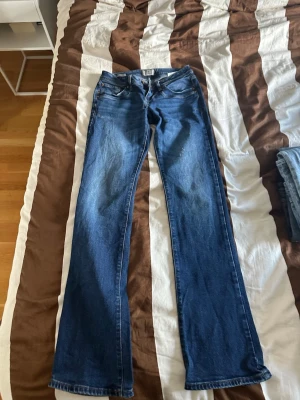 Mörkblå bootcut jeans - Säljer ett par mörkblå bootcut jeans med klassisk femficksdesign och normal midja. Jeansen har en lätt utsvängd passform nedtill och är tillverkade i denim med en snygg tvätt. Perfekta för dig som gillar en retroinspirerad look. Märke ltb storlek 27/36 modell VALERIE