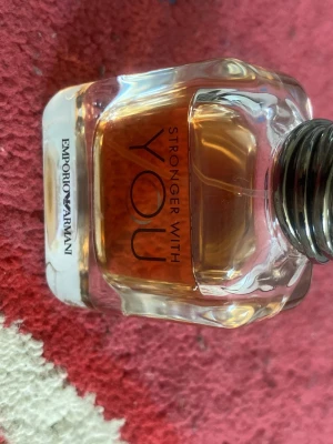 Emporio Armani Stronger With You parfym - Emporio Armani Stronger With You är en parfym i en stilren, fyrkantig glasflaska med rundade kanter. Doften har en varm bärnstensfärgad vätska och flaskan har en metallisk silverfärgad kork. Perfekt för dig som gillar eleganta och moderna dofter.