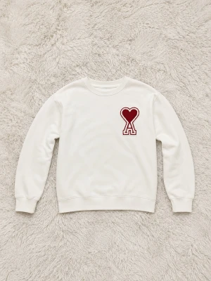 Vit Ami Heart sweatshirt  - Säljer en vit vit Amir Heart sweatshirt med en stor röd hjärtformad logga med bokstaven A på bröstet. Tröjan har rund halsringning, långa ärmar och ribbade muddar. Perfekt för dig som gillar minimalistisk design med en twist. Passar dig från 166-173cm