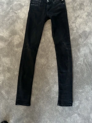 Svarta replay jeans  - Säljer ett par svarta skinny jeans med klassisk femficksdesign. Jeansen har smal passform hela vägen ner och är tillverkade i stretchigt material för extra komfort. Perfekta till en trendig och avslappnad stil. små fickor ifram.