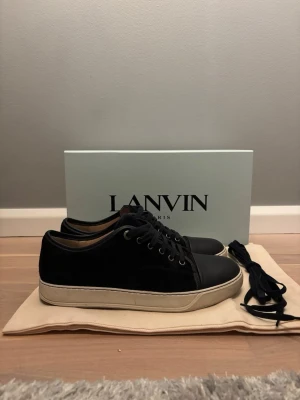 Blå Lanvin sneakers i läder - Priset kan förhandla!!! Stilrena blå sneakers från Lanvin i läder med vita sulor och svarta skosnören. Klassisk låg modell med rund tå och metallöljetter. Kommer med extra skosnören och originalkartong. Perfekta för dig som gillar exklusiva och tidlösa sneakers. 