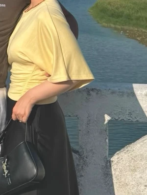 Gul topp med vida ärmar och rynk - Snygg ljusgul topp från Amattek med vida, korta ärmar och rynkdetalj i sidan. Tillverkad i mjuk bomull som känns skön mot huden. Perfekt till jeans eller kjol för en avslappnad men trendig look. Passar Stl S/M