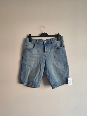 Blå jeansshorts från ASOS DESIGN - Säljer ett par supersnygga jeansshorts från ASOS DESIGN. Helt nya och oanvända med lappen/tagg kvar! ✨  Klassisk 5-ficksmodell i en fin blå denimtvätt som är enkel att matcha. Perfekta både till vardags och semester – styla med en enkel t-shirt för en avslappnad look eller klä upp med skjorta/linne ☀️  Skriv vid frågor, pris kan diskuteras - snabb affär prioriteras 