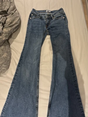 Blå utsvängda jeans bootcut - Säljer ett par klassiska blå jeans med bootcut och utsvängda ben. Perfekta för dig som gillar retrostil och vill ha ett par riktigt snygga jeans med breda ben.