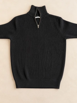 Svart stickad tröja med half zip - Svart stickad tröja med hög krage och half zip-dragkedja. Tröjan har ribbad struktur och långa ärmar, perfekt för kyliga dagar. Enkel och stilren design som passar till det mesta.