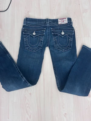 Super trendy Y2K vintage true religion jeans extremely lowwaisted, skinny/bootcut, bought in 2003 - Vintage bootcut/skinny low waisted 2000s (they were bought by my mom in the 2000s) jeans, they’re super low waisted and has classic true religion pockets and details, worn a few times but they’re to small for both me and my mom. Feel free to ask questions or give suggestions on the price! 💓 #lowwaisted #y2k #2000s #bootcut #truereligion #skinny #trendy