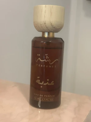 Brun parfymflaska med trälock - God parfym. Flaskan rymmer 50 ml och har en modern, Eau de Parfum med exklusiv känsla och elegant utseende. Använd fåtal gånger men har 90% av innehållet kvar. 
