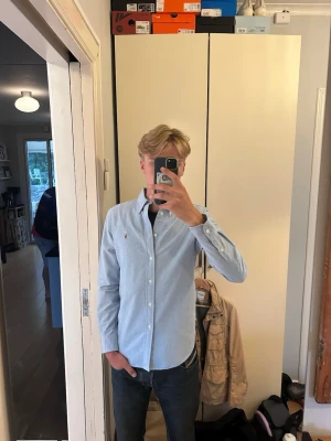 Ralph lauren skjorta - En stilren skjorta ifrån Ralph lauren som har en fler färgad logga, vilket ger en unik look. Skjortan är i mycket bra skick.