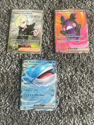 Pokémonkort Morpeko, Wailord EX & Gladion - Tre Pokémonkort: Morpeko V med färgstark bakgrund, Wailord EX med blått undervattenstema och Gladion’s Final Battle tränarkort. Helt nya fick dem igår.