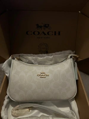 Coach Signature Shoulder bag - Aldrig använt, helt ny! Väldigt fräsch och elegamt! Medföljes dustbag, box samt ett vitt handtag och axelrem!