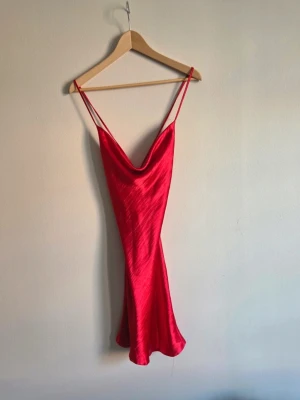 Röd satin klänning med snörning i ryggen - Fin röd satinklänning. Använd 1 gång. Liten defekt minimala, ytliga tråddragningar på framsidan (se sista bilden), inget som stör helhetsintrycket men vill nämna det. Skriv gärna vid frågor. Pris kan diskuteras ❣️