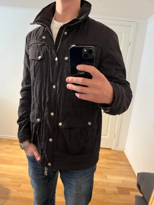 J.Lindeberg Fieldjacka svart  - Säljer denna sjukt snygga Fieldjackan från J.Lindeberg⭐️ Färgen är svart och storleken är L✅ Den har inga defekter och skicket är utomordentligt🙌🤝 Sjukt najs passform och passar perfekt till hösten☀️🙌 Tveka inte på att höra av er dig vid minsta fråga eller fundering😊