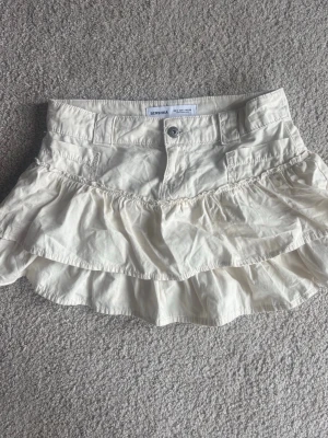 Vit jeans-volangkjol från Bershka - Supersöt vit kjol från Bershka med dubbla volanger och knappstängning framtill. Skriv om du vill köpa så sätter jag på köp nu.