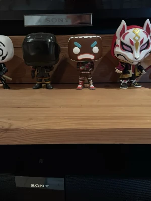  Funko Pop-figurer - Säljer en samling med fem Fortnite Funko Pop-figurer. Figurerna har olika färger och unika detaljer, bland annat en maskerad figur i vitt, en svartklädd karaktär, en pepparkaksgubbe och en rödvit rävliknande mask. Perfekt för dig som gillar gaming och samlarprylar.   135 st 500 för alla 