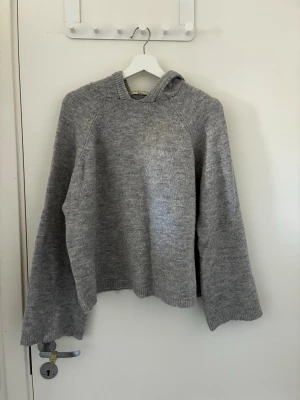 Grå stickad hoodie - Mysig grå stickad hoodie med luva och långa ärmar. Tröjan har en avslappnad passform. Perfekt för kyliga dagar och enkel att matcha. 💗🍵✨🥰