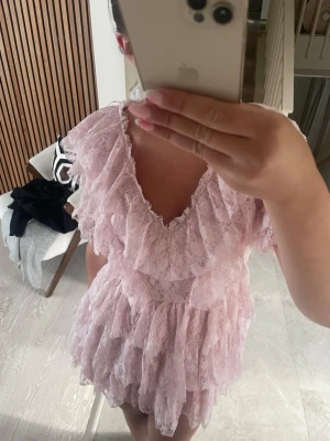 Rosa spetsklänning med volanger - Väldigt fin rosa klänning med spets och volanger från Gina tricot young. Storleken är M men skulle säga att den passar mer en S. Klänningen är oanvänd och ny och kommer med prislapp. 