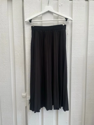 Svart långkjol med plisserad design - Säljer en svart plisserad kjol 