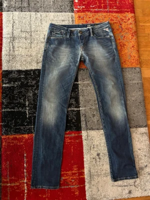 Replay jeans rocxanne  - Ett par stiliga jeans från replay, väldigt bra skick men med endast 2 små skrapor som får byxorna se bättre ut, blandade blå färger samt cool design med blå rand som drar sig runt bakre delen vid midjan. Skriv vid intresse!