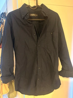 Mörkblå skjorta från dressman - Stilren mörkblå skjorta med klassisk krage och knappar framtill. Skjortan har en bröstficka och långa ärmar. Perfekt för dig som gillar en enkel men snygg look.