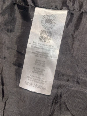Svart dunjacka från Canada Goose - Säljer en svart dunjacka från Canada Goose med avtagbar huva och pälskant. Jackan har två stora fickor framtill, ribbade muddar och klassisk patch på ärmen. Perfekt för kalla vinterdagar och riktigt varm tack vare dunfyllningen.
