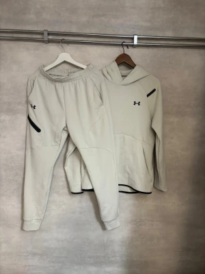 Under armour tracksuit  - Under Armour Set/tracksuit  Sällsynt och stilrent Under Armour-set i beige, i helt nytt skick. En ovanligare modell som är svår att hitta och ger en clean, sportig look.  • Storlek S • Beige • Helt nytt skick • Sällsynt modell • Nypris ca 2 500 kr  Skickas inom 1 timme!😊
