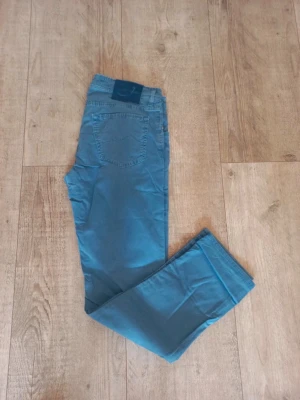 Blå jeans från Jacob Cohen - Snygga blå jeans från Jacob Cohen med klassisk femficksmodell och diskret logga på bakfickan. Jeansen har raka ben och är tillverkade i ett mjukt, bekvämt material som passar perfekt till en avslappnad stil.