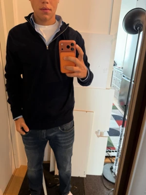 Mörkblå halvzip tröja - Snygg mörkblå tröja med halv dragkedja i kragen. Gjord av merinoull med lyxig känsla, säljer pågrund av för stor för mig, knappt använd 