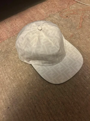 Fendi keps  - Säljer denna snygga vita Fendi keps i storlek One size, den går att reglera i storlek, riktigt snygg och stillig keps, pris kan diskuteras!! Tveka inte att skriva!!