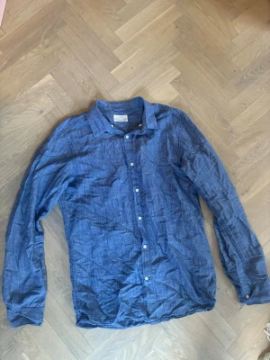 Linneskjorta knowledge cotton apparel - Blå skjorta i linne med klassisk krage och knappar framtill. Bra skick. Relativt smal storlek M