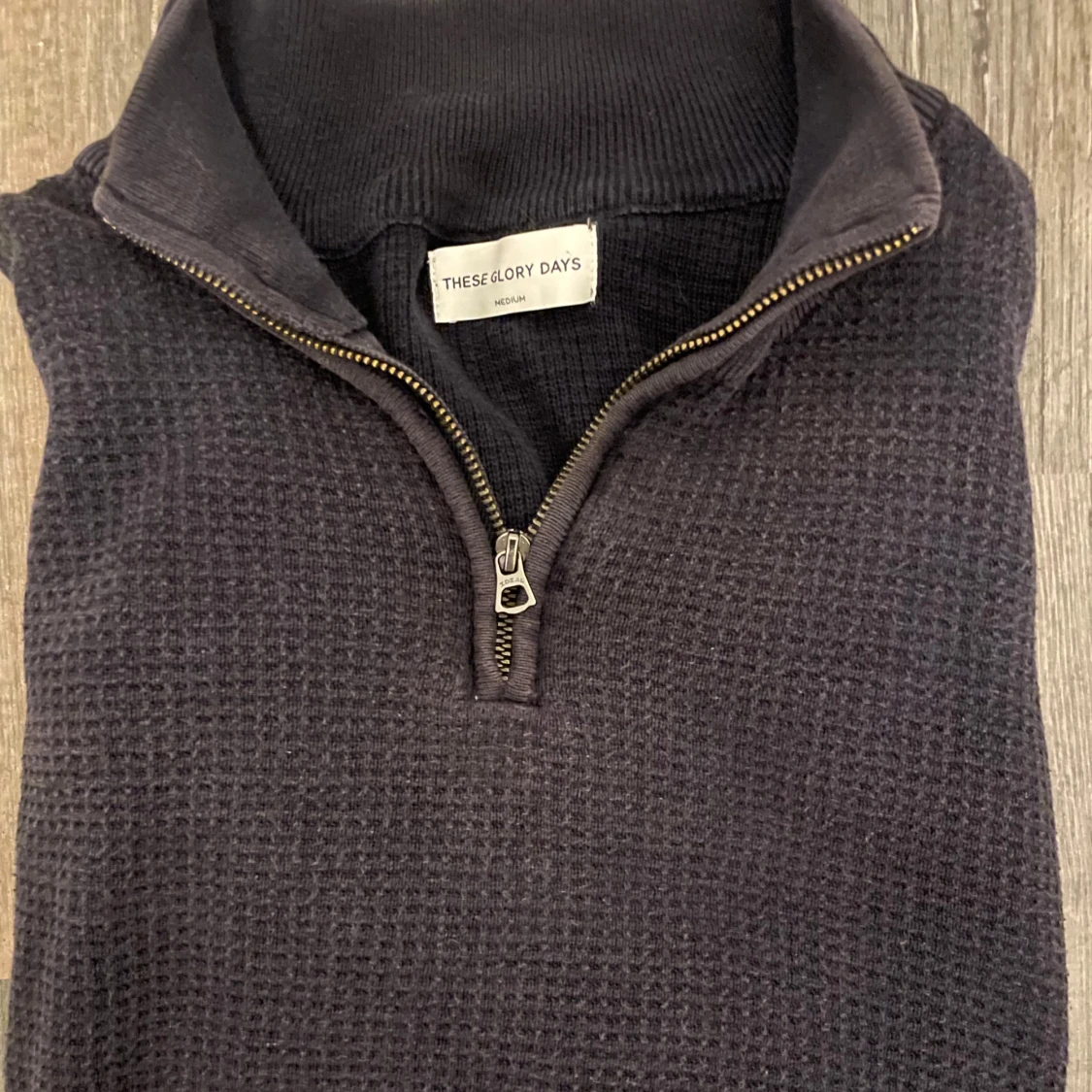 Mörkblå stickad half zip från These Glory Days