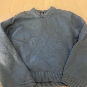 Ljusblå stickad tröja Gina Tricot - Ljusblå stickad tröja från Gina Tricot i storlek XS. Tröjan har rund halsringning, ribbade muddar och är långärmad. Perfekt för lager-på-lager och enkel att matcha med jeans eller kjol.