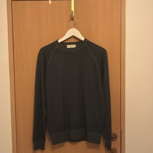 Mörkgrå tröja från Filippo de Laurentiis - Säljer en stilren mörkgrå tröja från Filippo de Laurentiis. Tröjan har rund halsringning, långa ärmar och ribbade muddar. Perfekt för dig som gillar en enkel och klassisk look. Materialet känns mjukt och passar bra till lager-på-lager.
