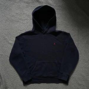 Mörkblå hoodie från Polo Ralph Lauren - Fin mörkblå hoodie från polo Ralph lauren👕 mycket bra skick, inga hål men något urtvättad✅ skickar snabbt efter att du har beställt📦