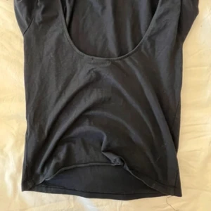 Svart kortärmad topp från Gina Tricot - En basic svart topp från Gina Tricot i mjuk bomull. Modellen är enkel med rund halsringning och korta ärmar, perfekt att matcha med jeans eller kjol. Stilren och tidlös design som funkar till många olika looks.