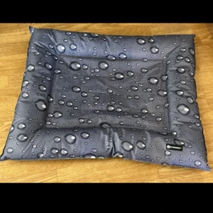 Flamingo Vattenavvisande Dyna - Bekväm och slitstark dyna från Flamingo med vattenavvisande yta och snyggt dropp-mönster. Perfekt för husdjur, lätt att rengöra och i mycket gott skick utan synligt slitage. Passar både inomhus och utomhusbruk.