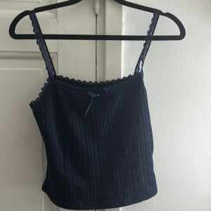 Mörkblå spetskantad linnetopp - Supersöt mörkblå linnetopp med smala axelband och spetskant upptill.