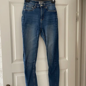 Blå skinny jeans med hög midja - Snygga blå skinny jeans från lager 157 med hög midja och klassisk femficksdesign. Jeansen har en lätt tvättad look och smal passform hela vägen ner. Perfekta för dig som gillar en tight och modern stil.