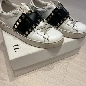 VALENTINO GARAVANI SNEAKERS 💛🖤 - Ovanlig ikonisk Rockstud edition med guld detalj.  Skorna är tillverkade av premium läder, handgjorda i Italien. Ingår: Dustbag (valentino), nya extra skosnören (vita), original skokartong + äktehetsbevis 🪪. 