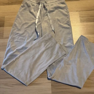 Ljusblåa mjukisbyxor från Gina Tricot - Superbekväma ljusblåa mjukisbyxor från Gina Tricot med dragsko i midjan. Byxorna har raka ben och är gjorda i mjukt material som passar perfekt för chill dagar. Snygg och enkel design med bred resår i midjan och långa ben.