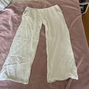 Vita linnebyxor från Lager 157, storlek M - Säljer ett par vita linnebyxor från Lager 157 i storlek M. Byxorna har rak passform, resår i midjan och snörning för extra komfort. Perfekta för varma dagar och har en avslappnad vibe. Materialet är svalt linne och färgen är klassiskt vit. Extra snygga att stryka innan användning💕