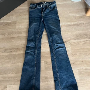 Blå bootcut jeans från Gina Tricot - Snygga blå jeans från Perfect Jeans i klassisk bootcut-modell. Jeansen har fem fickor, normal passform och är tillverkade i slitstarkt denim. Perfekt för dig som gillar en tidlös look med lite utsvängda ben.