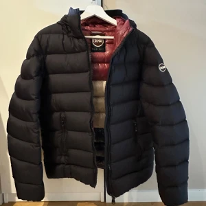 Svart Colmar jacka  - Tjena! Jag säljer nu en riktigt varm vinterjacka ifrån colmar i storlek 46 vilket motsvarar small. Jackan har ett litet hål på högerarmen som syns på bild 3. Hålet syns däremot inte vid användning och är lätt att täcka över med en lagningslapp. Utöver det är jackan i bra skick och perfekt för kalla vinterdagar. Priset är ej hugget i sten!