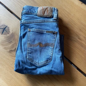 Ljusblå Nudie jeans  - Säljer nu ett år riktigt snygga Lean Dean nudie jeans. Storleken är W27 L28 men sitter större. Jeansen är använda max 3 gånger. Kontakta vid frågor eller fler bilder. Nypris: 1400