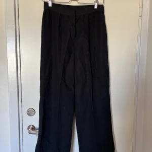 Svarta linnebyxor från H&M - Svarta linnebyxor från H&M i storlek 38. Byxorna har en rak passform med hög midja och är i  linneblandning (55% viskos, 45% linne). Stl 38 men ganska små i midjan, skulle säga att de passar som 36/S. 