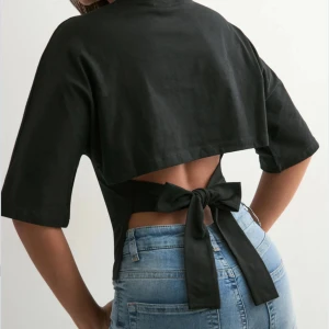 Knyt topp - Jag säljer en svart t shirt med knyt detalj i ryggen. Den är i storlek M och är i ifrån Nelly. Bara använd en gång och inga fläckar så den ser helt ny ut!