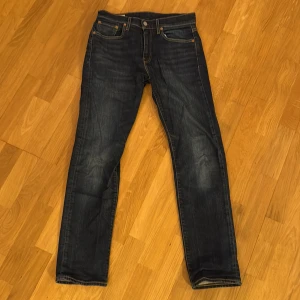 Levi's 502 mörkblå jeans - Snygga Levi's 502 jeans i mörkblå tvätt med klassiska fem fickor och gul kontrastsöm. Jeansen har en slim passform och raka ben, tillverkade i slitstarkt bomullsjeans. Perfekta för dig som gillar en stilren och tidlös look. Dom är byxorna är lika modellen 501 men är Lite mer stretchiga vilket gör dom skönare. Säljer för dom ej passar mig längre 