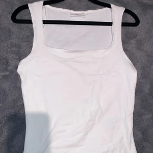 Vit linnetopp xs - Säljer en gullig klassisk vit linne topp. Toppen har breda axelband och parfekt fyrkantig ringning. Tillverkad i mjuk bomull, perfekt för en enkel och clean look.